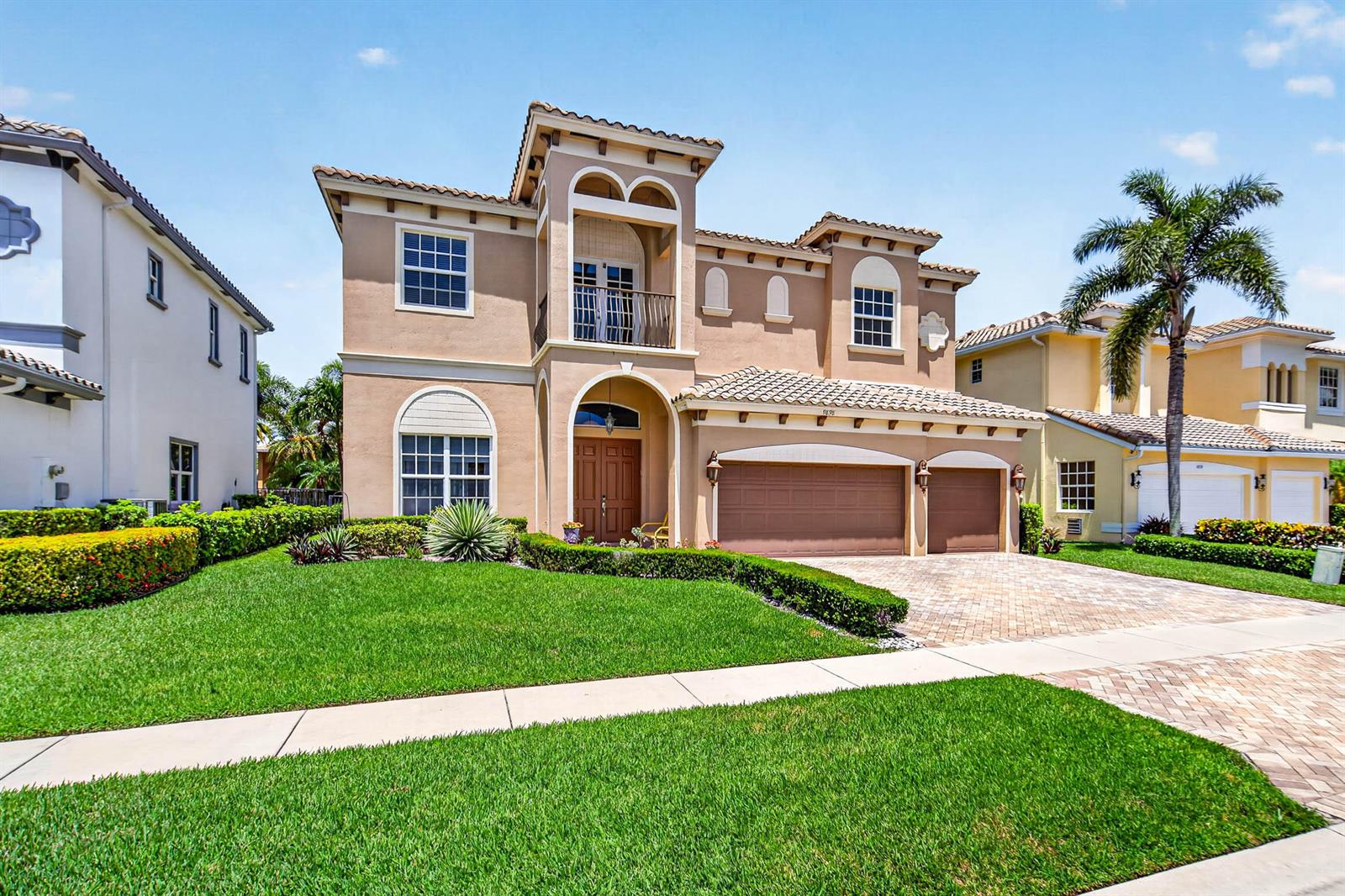 A two-story Mediterranean-style house with a tan stucco exterior, a tile roof, and a driveway — 9898 Coronado Lake Drive, Boynton Beach FL 33437, BOYNTON BEACH, FL