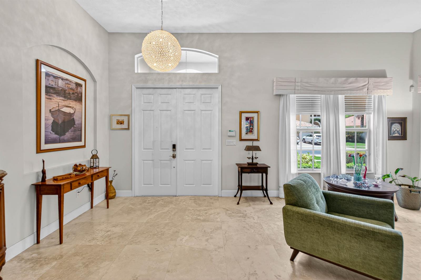 A bright foyer features large stone floor tiles, a double front door, and a crystal chandelier — 9898 Coronado Lake Drive, Boynton Beach FL 33437, BOYNTON BEACH, FL