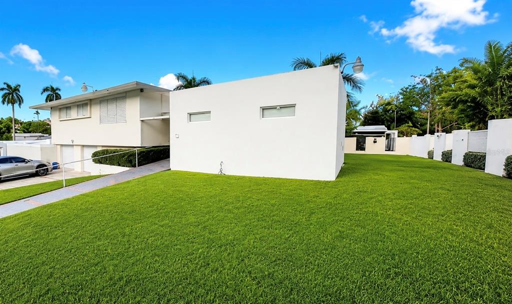 A white, modern house exterior features a large green lawn and a paved driveway — D-15 GREEN VALLEY UNIT D-15, GUAYNABO, PR
