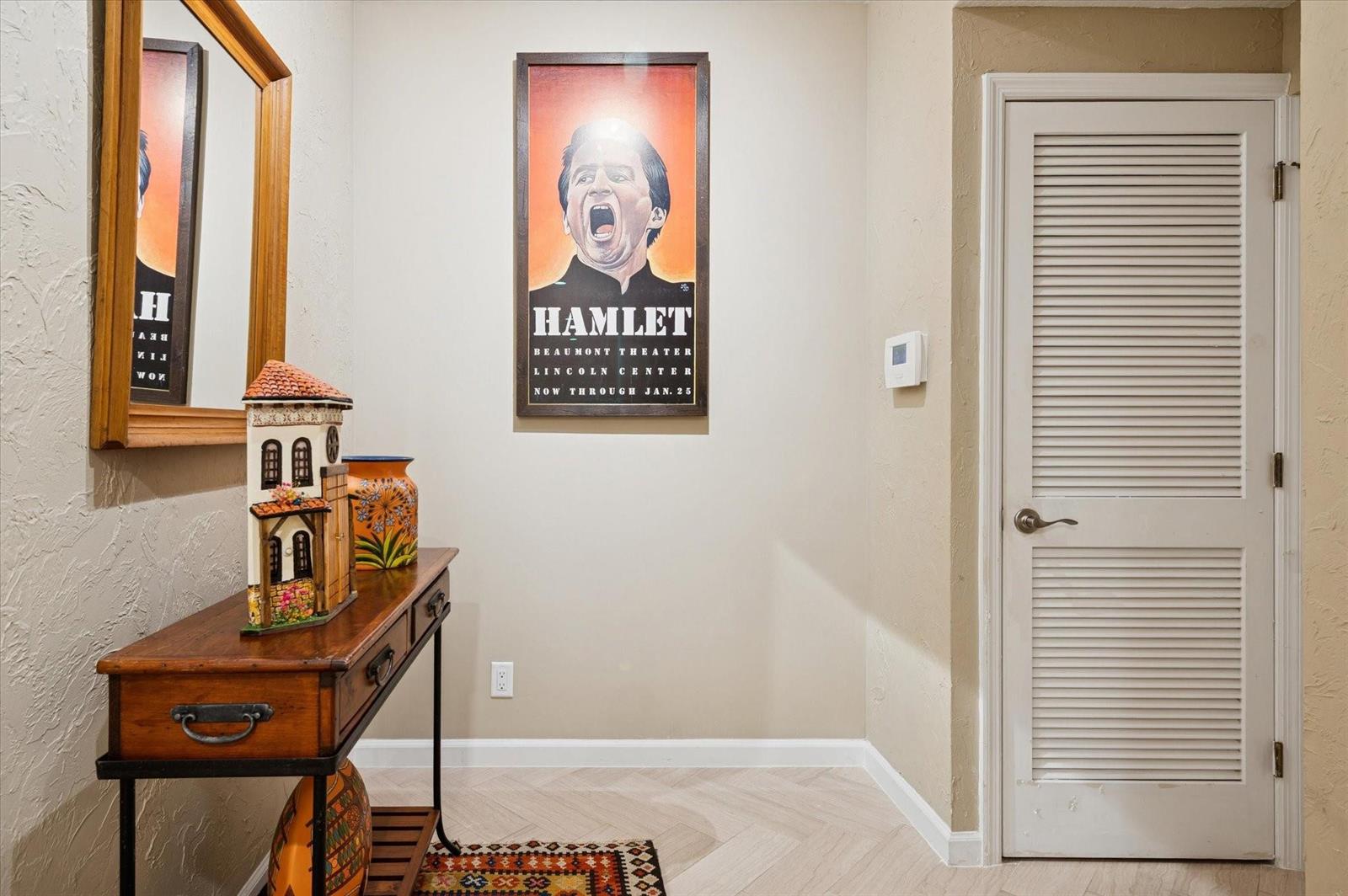 A hallway features a wooden console table, a Hamlet poster, and a white louvered door — 4112 W Palm Aire Drive # 124a, Pompano Beach FL 33069, POMPANO BEACH, FL