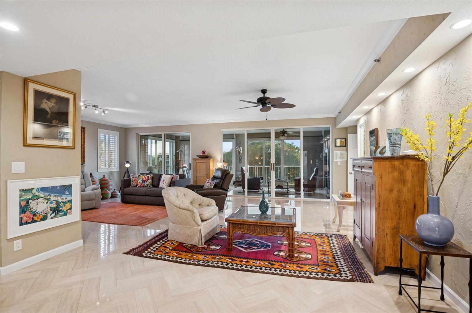 A spacious living room features tile flooring, two area rugs, and large sliding glass doors — 4112 W Palm Aire Drive # 124a, Pompano Beach FL 33069, POMPANO BEACH, FL