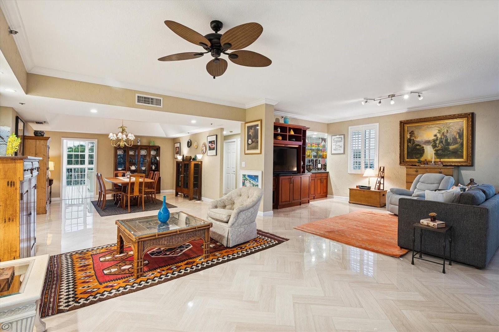 An open-concept living and dining area features tile flooring, a ceiling fan, and area rugs — 4112 W Palm Aire Drive # 124a, Pompano Beach FL 33069, POMPANO BEACH, FL