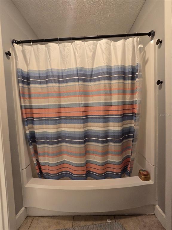 A shower with a striped curtain and white surround in a bathroom — 2115 NE 38TH AVENUE, OCALA, FL