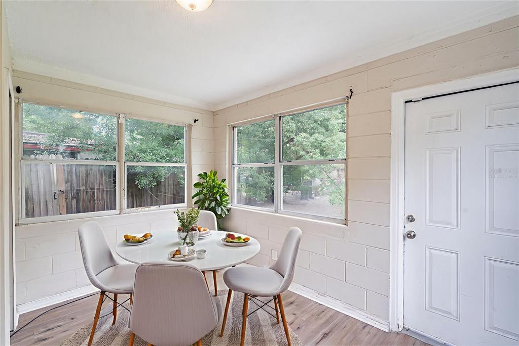 A dining area features a round white table, four chairs, and windows overlooking a backyard — 4345 AETNA DRIVE, ORLANDO, FL