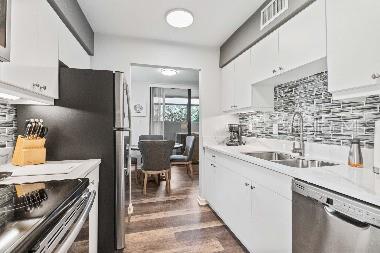 A kitchen features white cabinets, a black refrigerator, stainless steel appliances, and a tiled backsplash — 3071 WILLOW GREEN UNIT 35, SARASOTA, FL