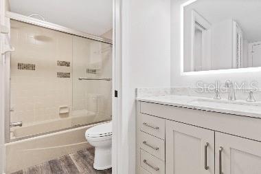 A bathroom features a white vanity with a mirror, a toilet, and a tub-shower combination — 3071 WILLOW GREEN UNIT 35, SARASOTA, FL