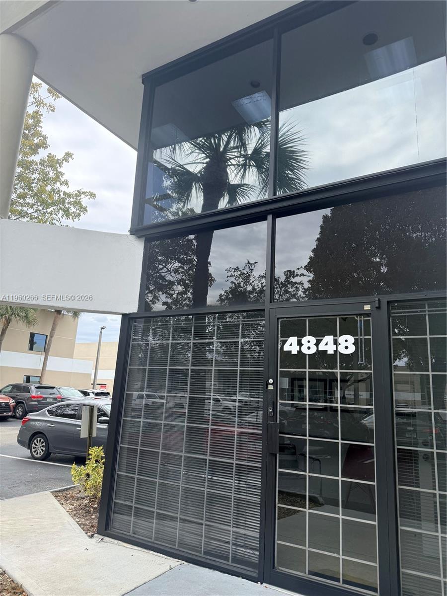 The exterior of a commercial building features a glass storefront entrance with the number 4848 — 4848 SW 74th Ct # 9, Miami FL 33155, MIAMI, FL