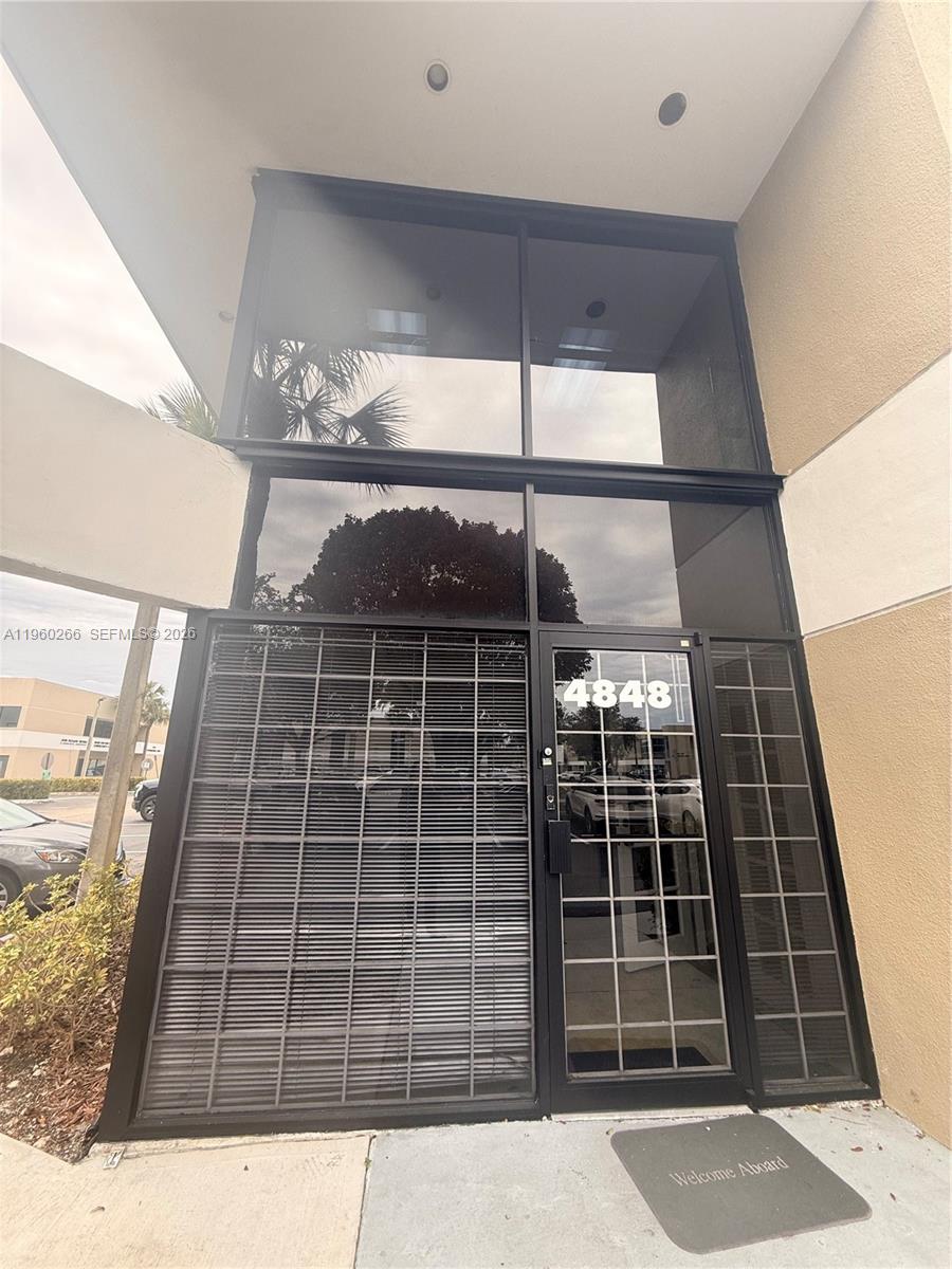 The exterior entrance of a commercial building features a glass door and large windows — 4848 SW 74th Ct # 9, Miami FL 33155, MIAMI, FL