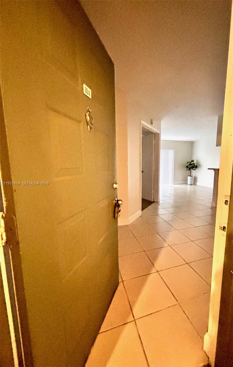 A view from an open doorway into a tiled entryway leading toward a living area — 450 S Park Rd # 104, Hollywood FL 33021, HOLLYWOOD, FL