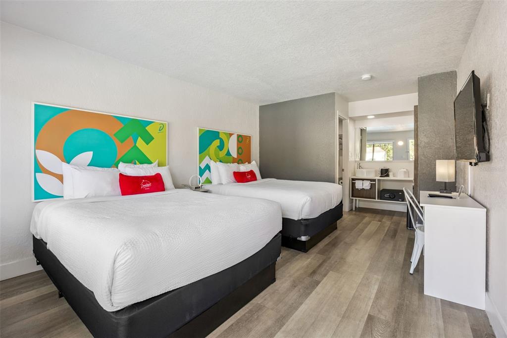 A hotel room features two queen beds, a desk, and a vanity area with wood-look flooring — 5367 W IRLO BRONSON MEMORIAL HIGHWAY UNIT 1-209, KISSIMMEE, FL