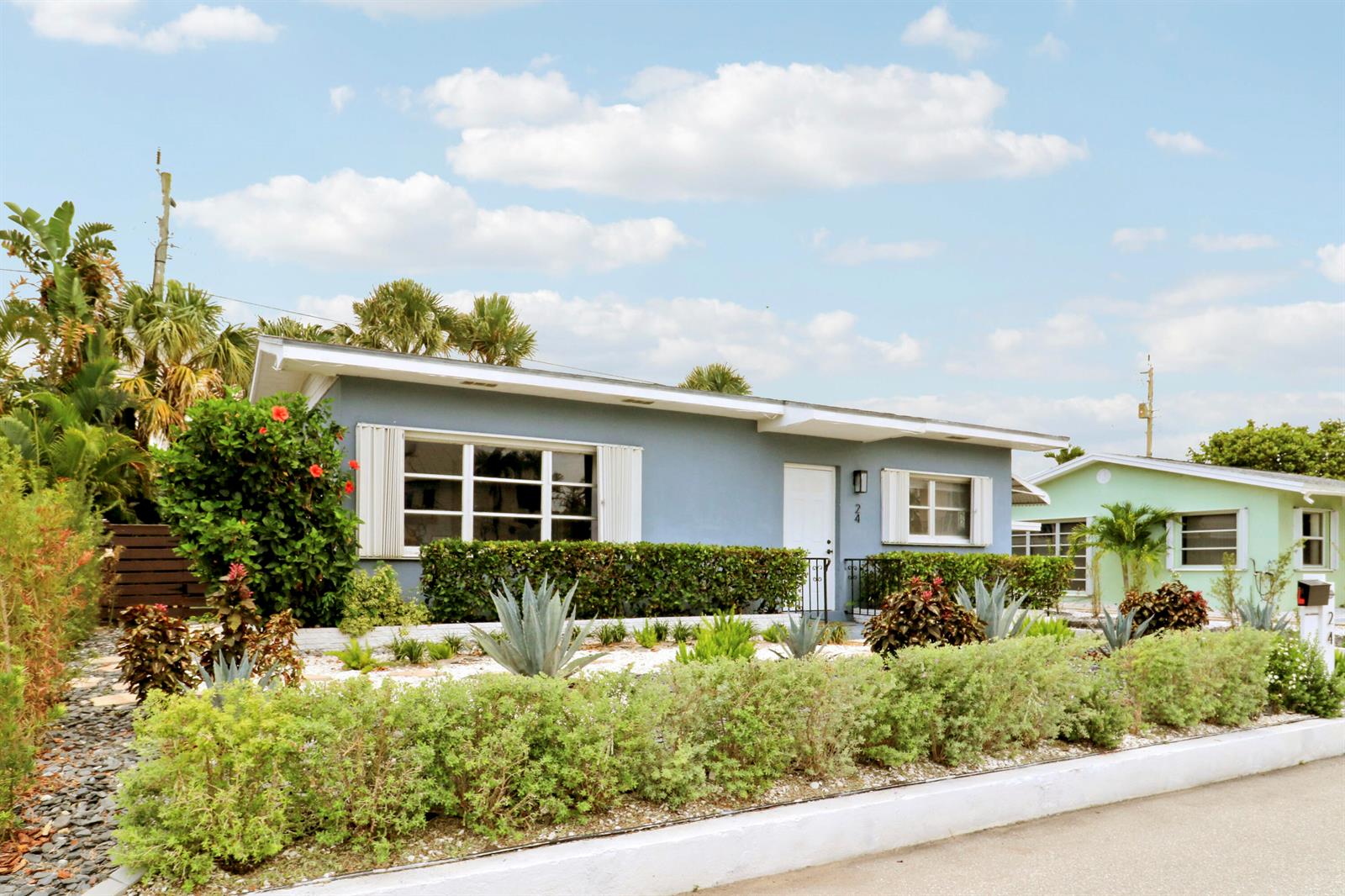 A blue single-story house with white trim, shutters, and a landscaped front yard — 24 Douglas Drive, Ocean Ridge FL 33435, OCEAN RIDGE, FL