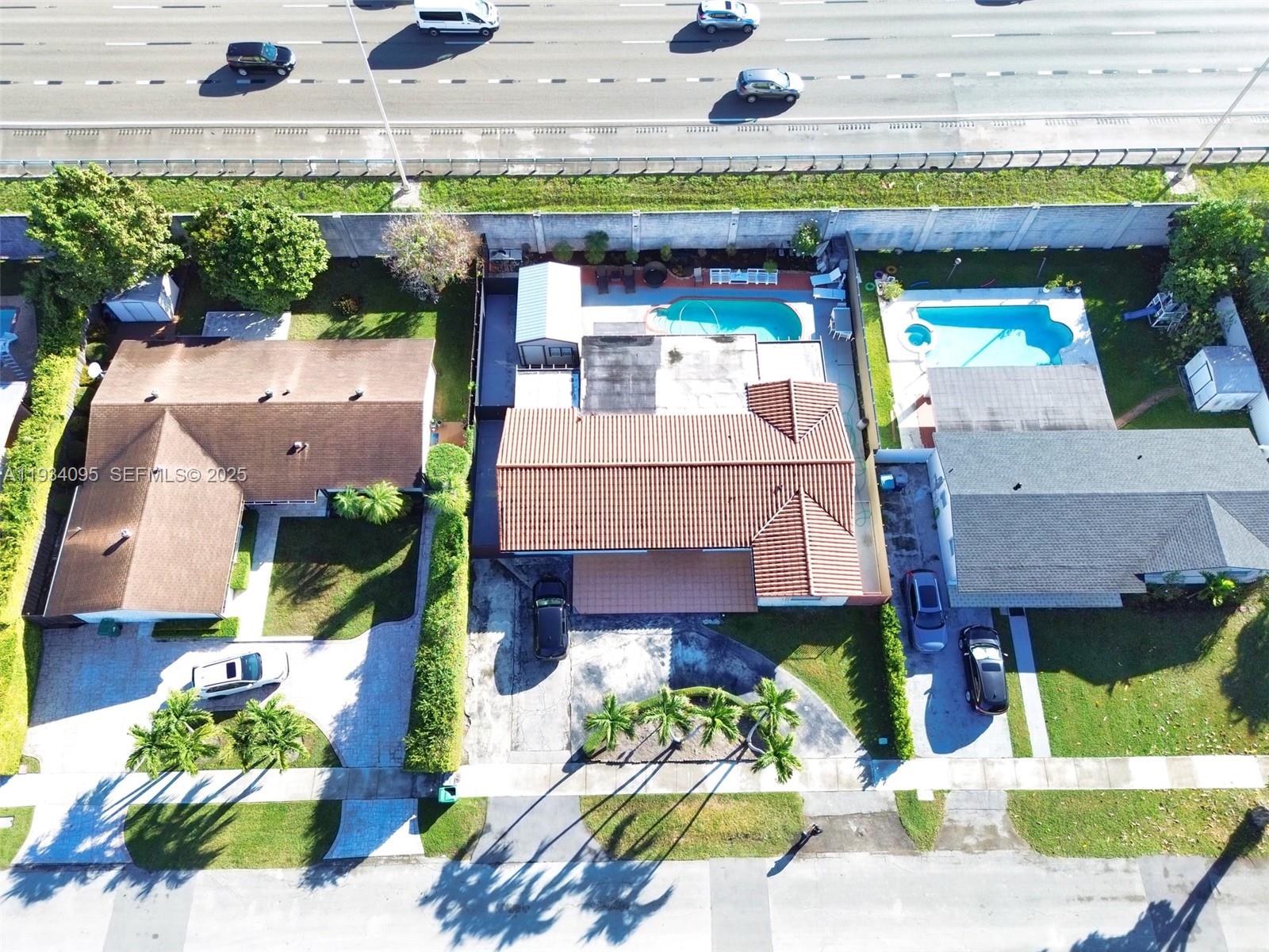 Aerial view of three suburban houses with swimming pools located next to a highway — 2711 SW 117th Ct, Miami FL 33175, MIAMI, FL