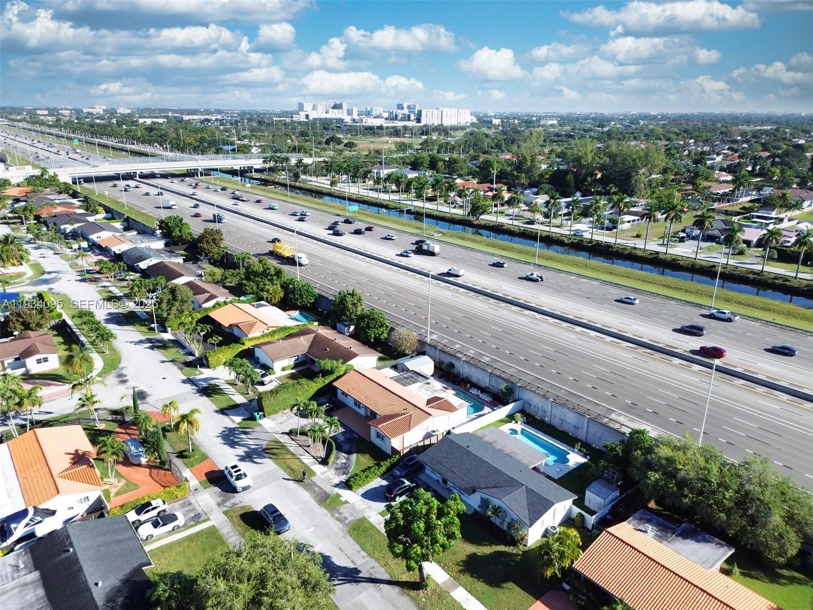 An aerial view shows a suburban neighborhood adjacent to a multi-lane highway and canal — 2711 SW 117th Ct, Miami FL 33175, MIAMI, FL