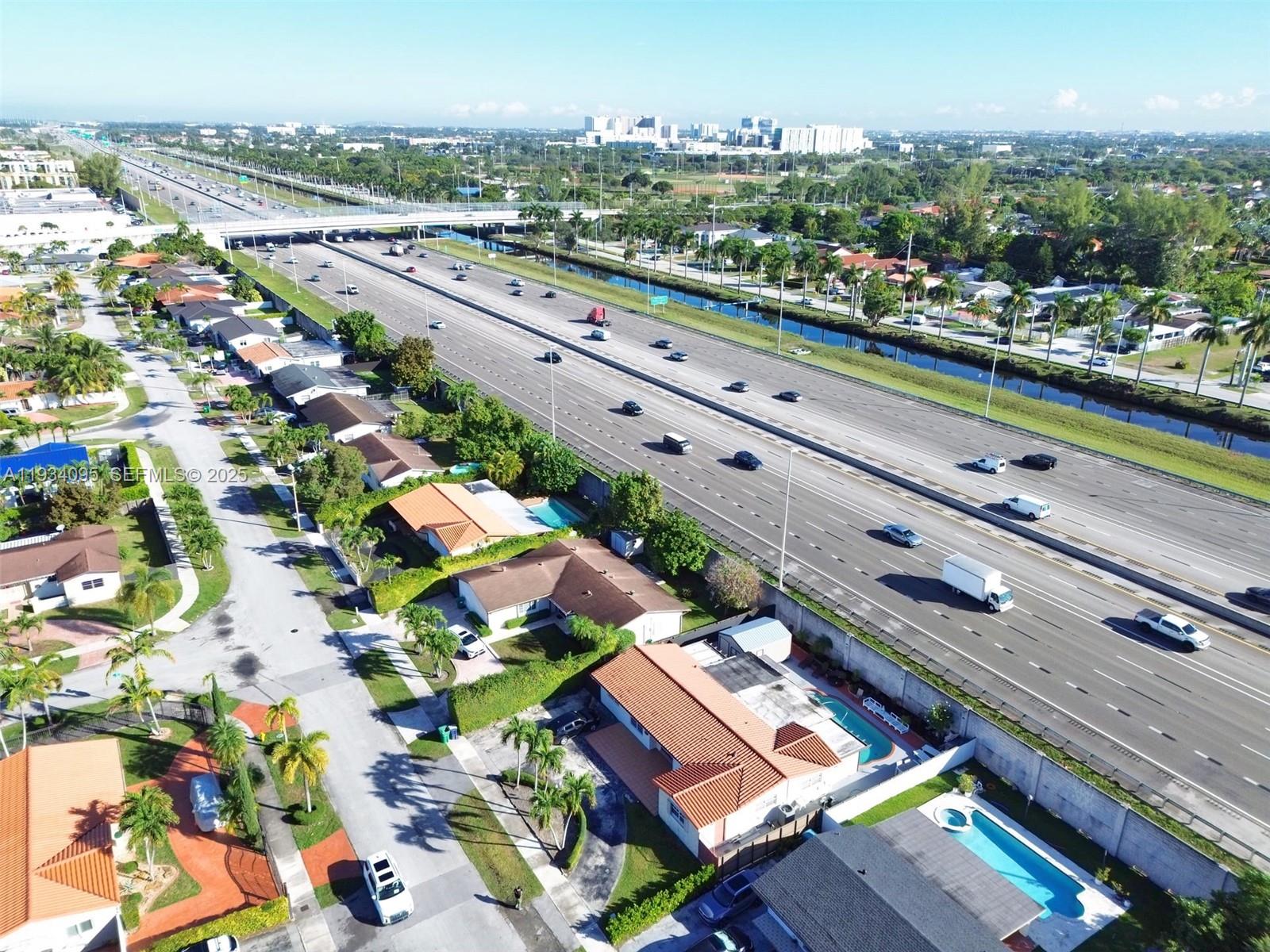 An aerial view shows residential homes with pools situated next to a multi-lane highway — 2711 SW 117th Ct, Miami FL 33175, MIAMI, FL