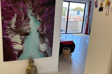 A large nature print hangs on a wall next to a doorway leading to a balcony — 17600 NW 68th Ave # B4002, Hialeah FL 33015, HIALEAH, FL