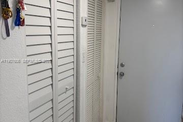 A hallway features two white louvered closet doors next to a solid white entry door — 17600 NW 68th Ave # B4002, Hialeah FL 33015, HIALEAH, FL