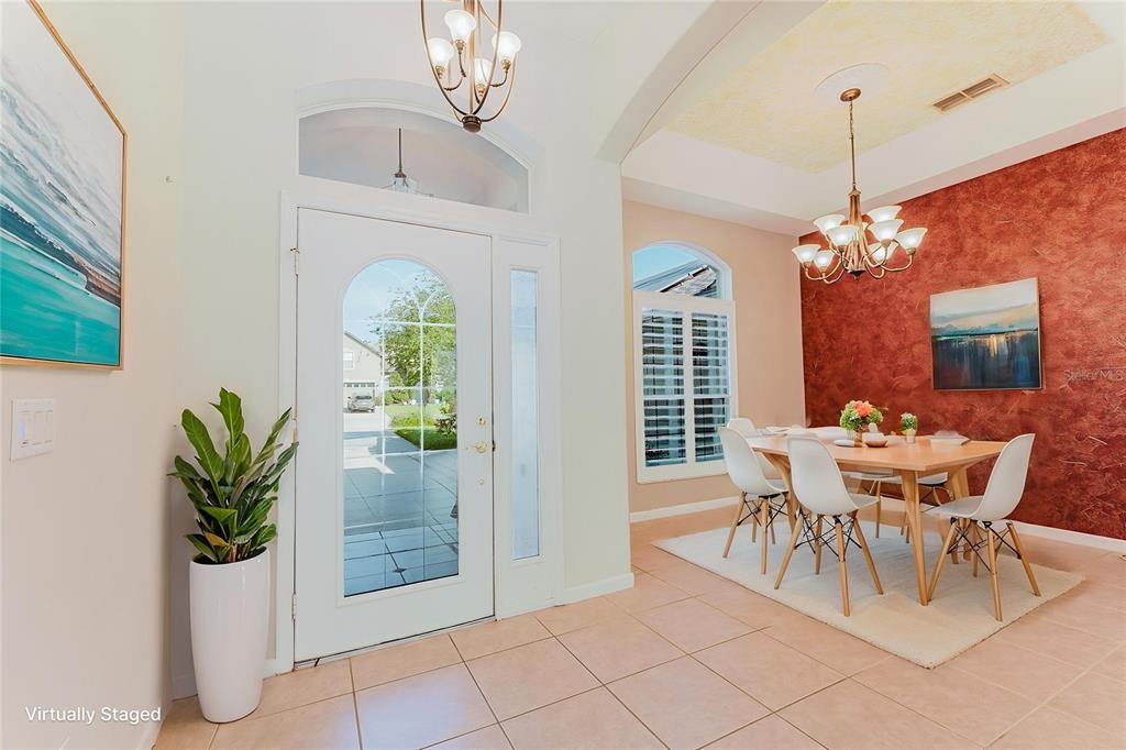 A bright entryway features tile flooring, a white front door, and an adjacent dining area — 3645 ROCHELLE LANE, APOPKA, FL