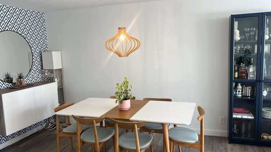 A dining room features a wooden pendant light, a white table, and a dark cabinet — 1913 S.Ocean dr. # 429, Hallandale Beach FL 33009, HALLANDALE BEACH, FL