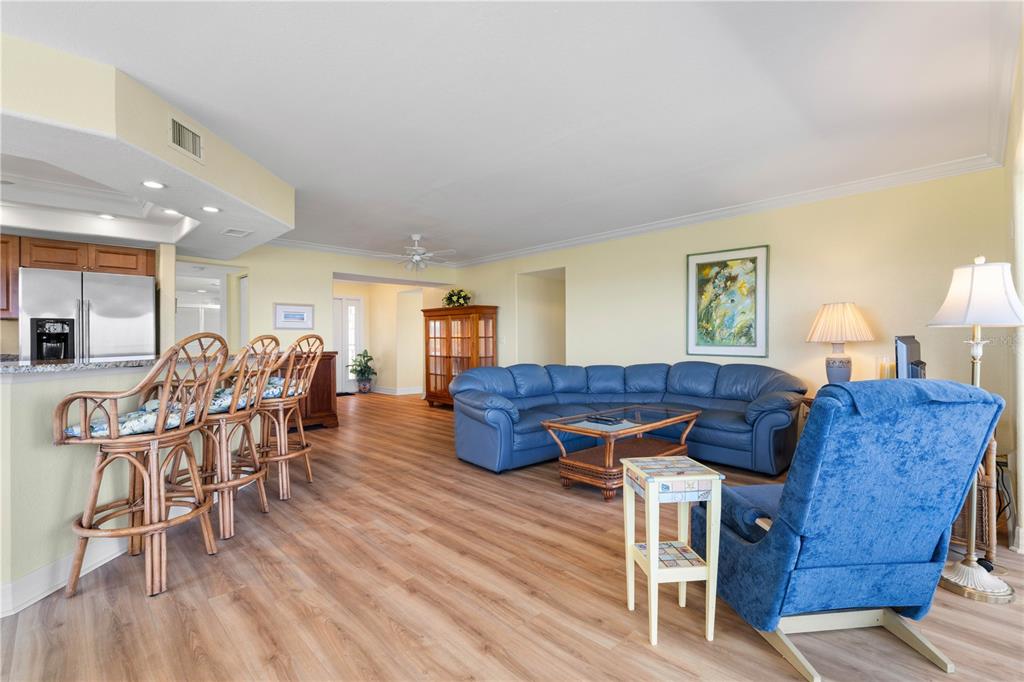 A living room with a blue sectional sofa, a matching armchair, and a kitchen breakfast bar — 101 N MARION COURT UNIT 215, PUNTA GORDA, FL