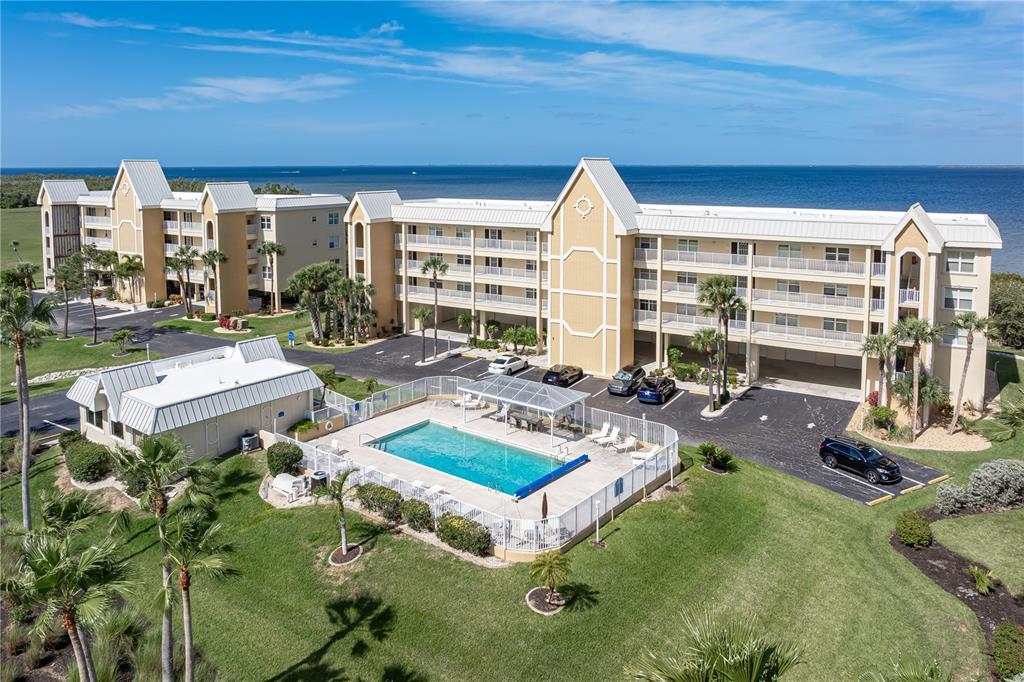 An aerial view shows a multi-story apartment complex with a swimming pool and parking lot — 101 N MARION COURT UNIT 215, PUNTA GORDA, FL