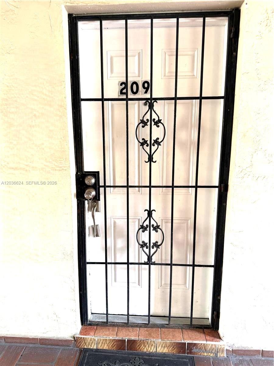 A white door with a black security gate and the number 209 is visible — 6070 W 18th Ave # 209, Hialeah FL 33012, HIALEAH, FL