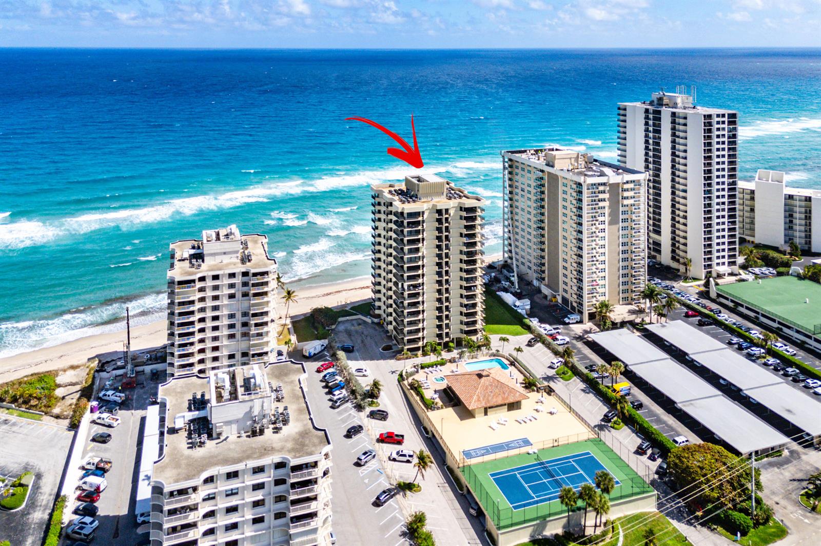 An aerial view shows high-rise residential buildings along a sandy beach and the ocean — 5460 N Ocean Drive # 5b, Singer Island FL 33404, SINGER ISLAND, FL