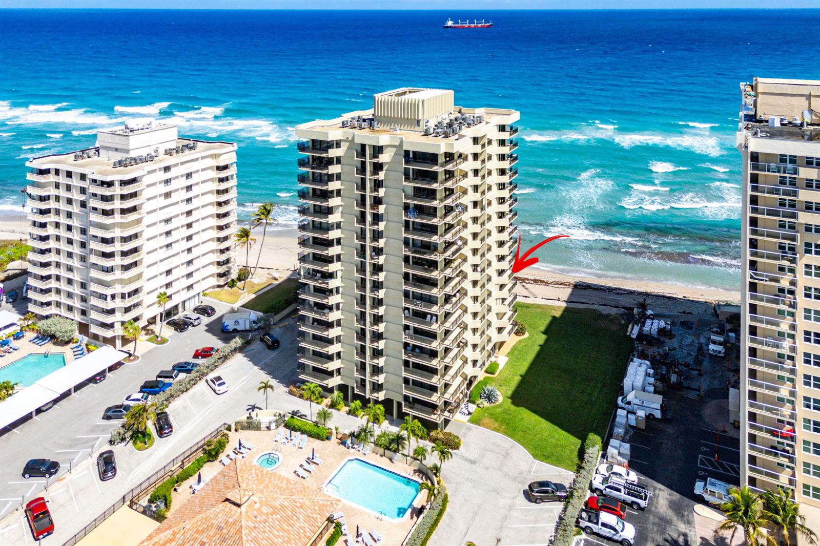 An aerial view shows three tall residential buildings situated along a sandy beach and ocean — 5460 N Ocean Drive # 5b, Singer Island FL 33404, SINGER ISLAND, FL