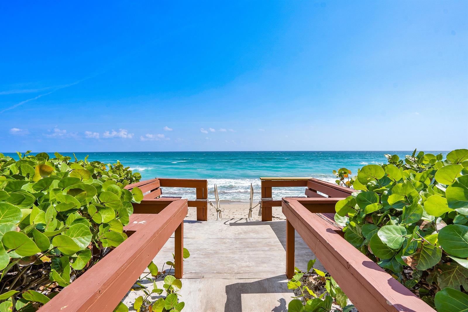 A wooden walkway with benches leads through sea grape bushes to a sandy beach — 5460 N Ocean Drive # 5b, Singer Island FL 33404, SINGER ISLAND, FL