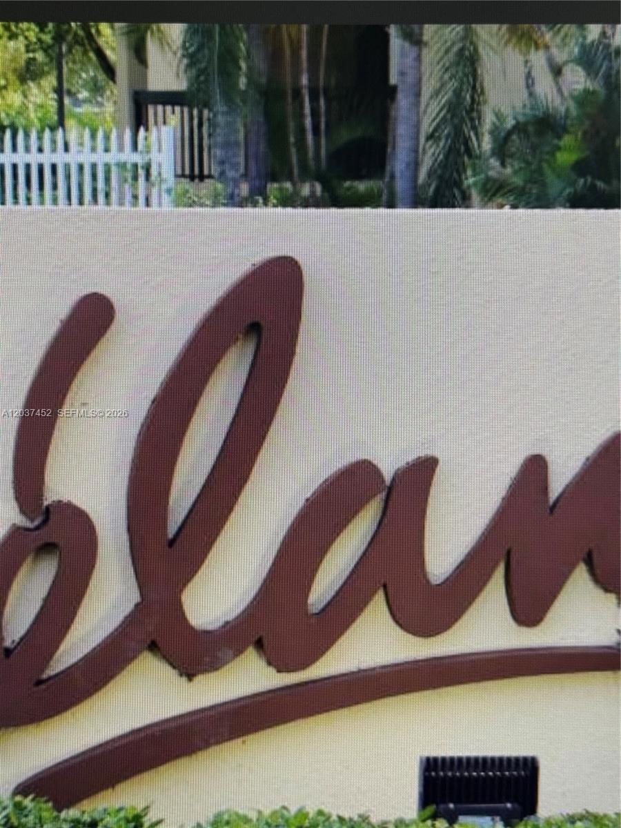 A close-up view of a brown, cursive-style sign reading "Island" mounted on a beige wall — 12910 SW 88th Ter # 203, Miami FL 33186, MIAMI, FL
