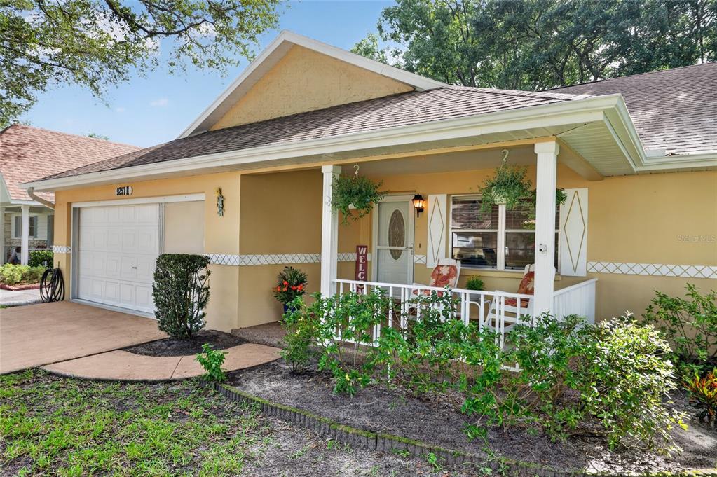 A single-story house with a tan stucco exterior, a front porch, and an attached garage — 9257 SW 82ND TERRACE UNIT H, OCALA, FL