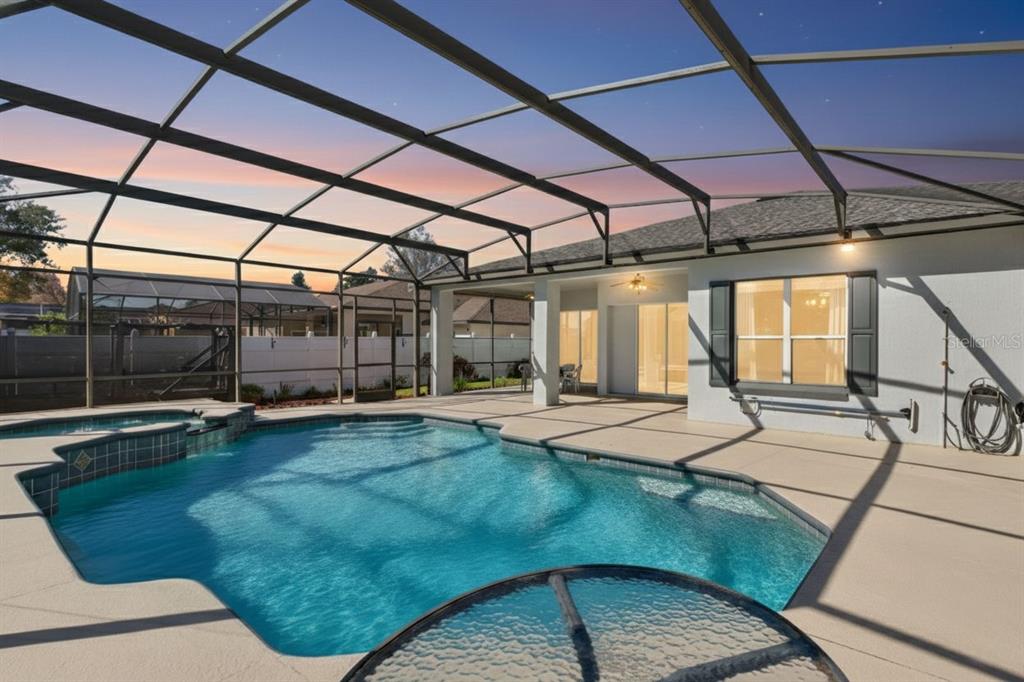 A screened-in patio features a swimming pool with a spa and a concrete deck — 365 VIA BIANCA DRIVE, DAVENPORT, FL