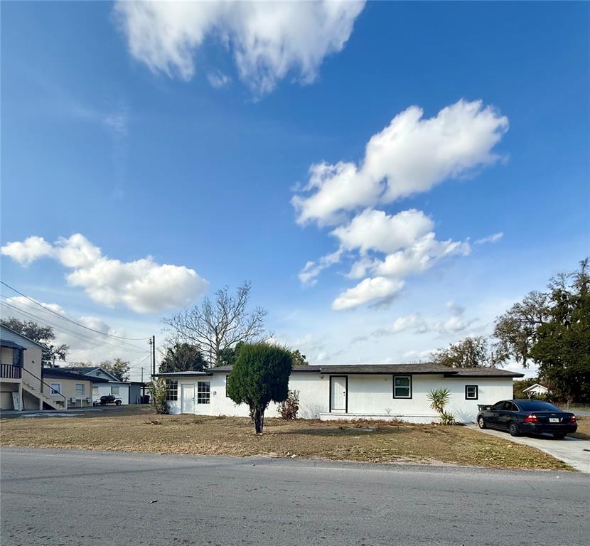 A single-story white house with a dark roof sits on a grassy lot — 1550 E BAY STREET, BARTOW, FL