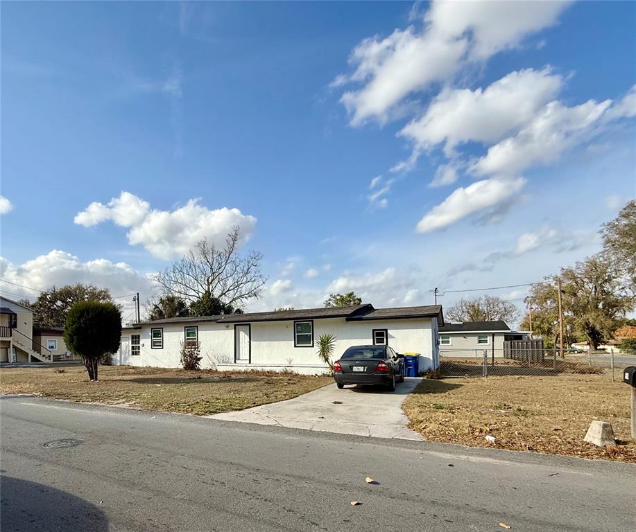 A single-story white house with a concrete driveway and a parked car in front — 1550 E BAY STREET, BARTOW, FL