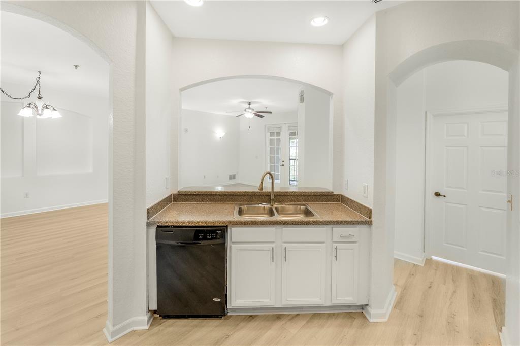 A kitchen sink and dishwasher are set into a countertop with white cabinets below — 3351 WHITESTONE CIRCLE UNIT 304, KISSIMMEE, FL