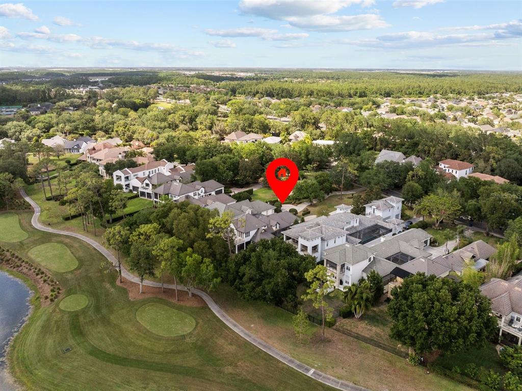 An aerial view shows a large house with a pool situated on a golf course — 9744 COVENT GARDEN DRIVE, ORLANDO, FL