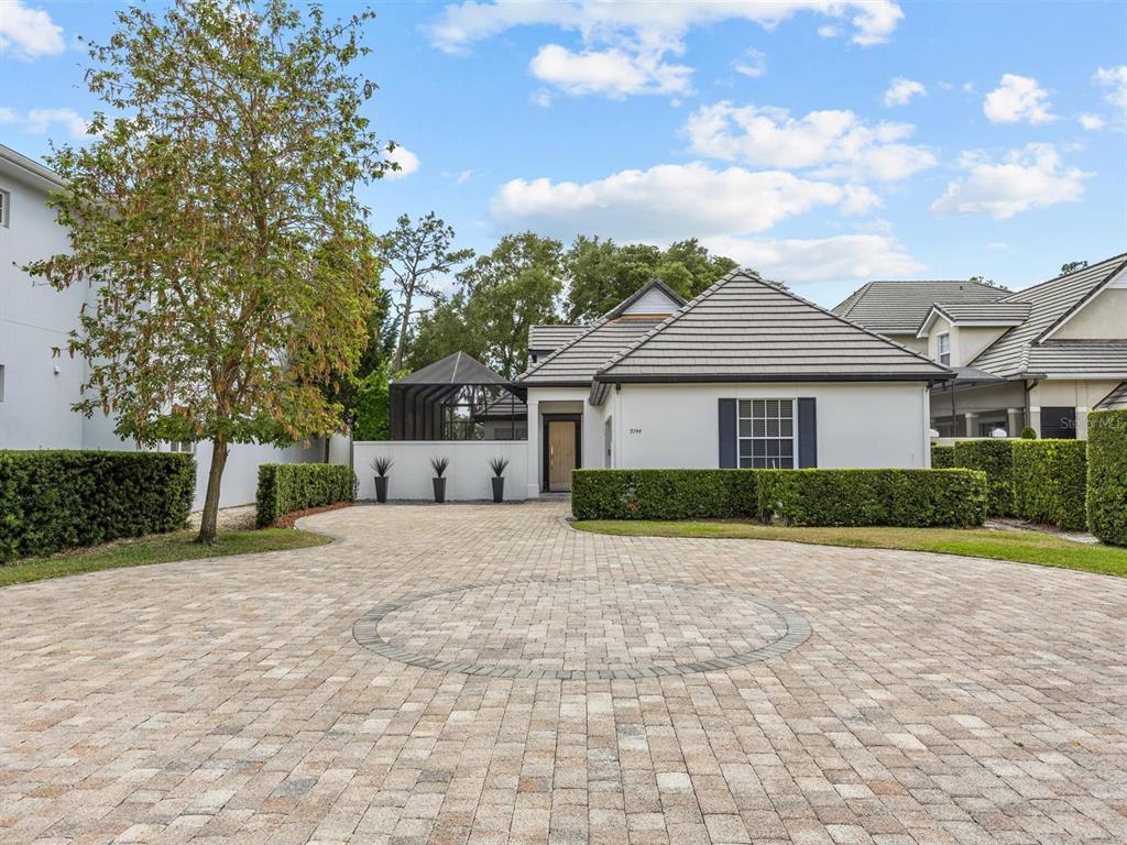 A single-story house with a paved circular driveway, a front hedge, and a screened enclosure — 9744 COVENT GARDEN DRIVE, ORLANDO, FL