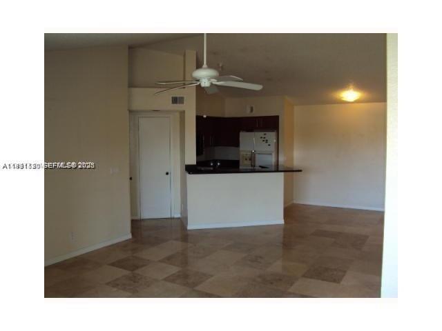A view of a living area with tile flooring, a ceiling fan, and an open kitchen — 3300 N Pinewalk Dr N # 1928, Margate FL 33063, MARGATE, FL