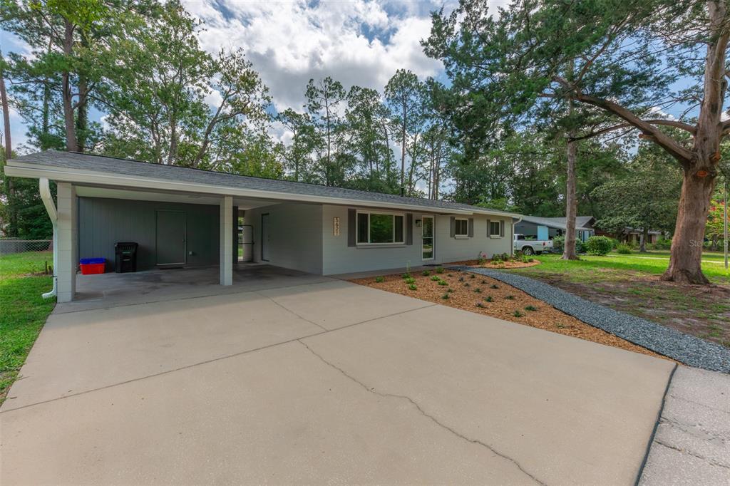 A single-story house with a gray exterior, a carport, and a concrete driveway — 5621 NW 29TH TERRACE, GAINESVILLE, FL
