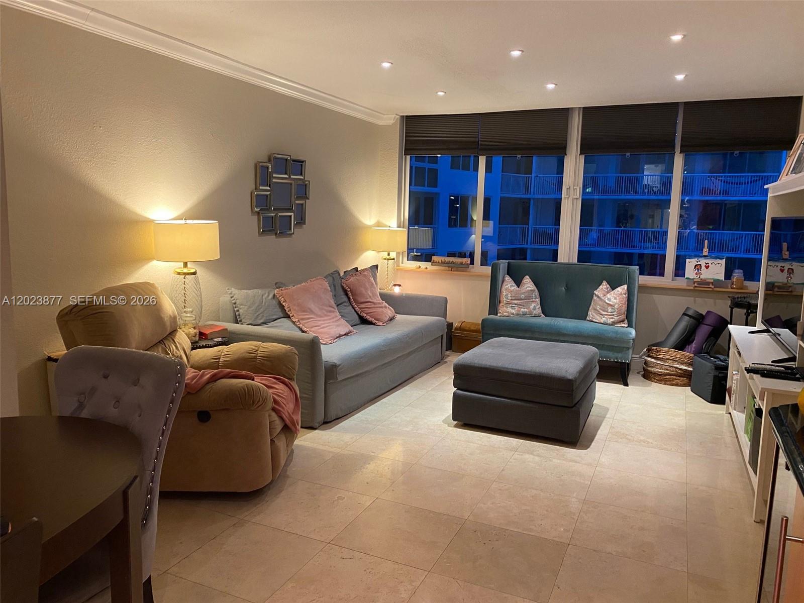 A living room features tile flooring, a gray sofa, a blue settee, and a recliner — 5401 Collins Ave # 339, Miami Beach FL 33140, MIAMI BEACH, FL