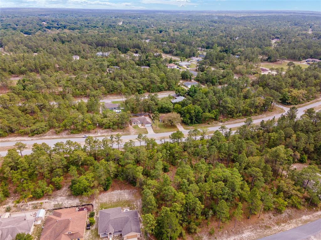 An aerial view shows a suburban neighborhood with houses surrounded by dense pine forests — 9200 N CITRUS SPRINGS BOULEVARD, CITRUS SPRINGS, FL