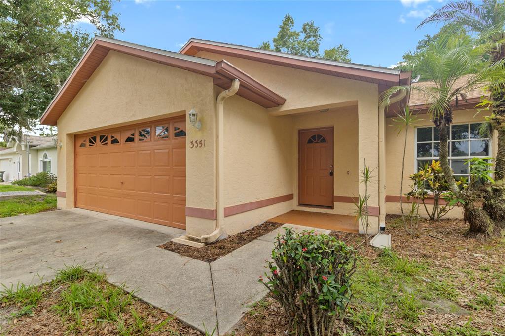 A single-story house with a tan stucco exterior, a brown garage door, and a front entrance — 3351 TUCSON ROAD, NORTH PORT, FL