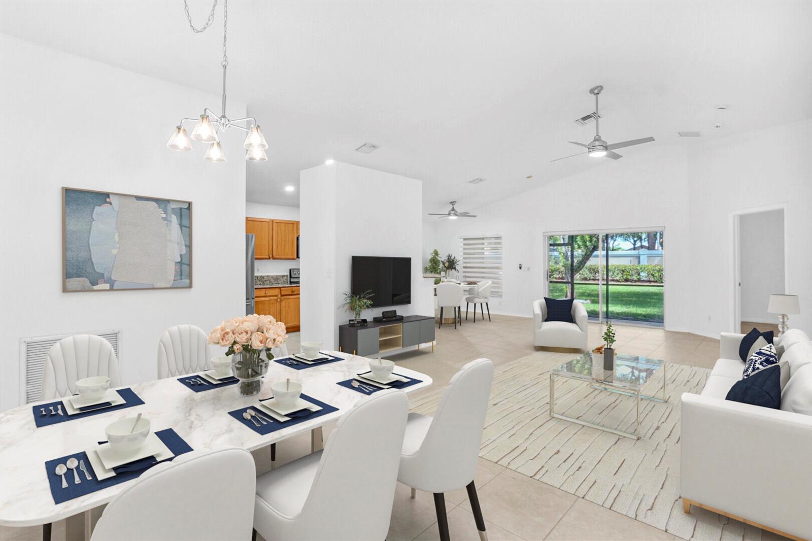 An open-concept living and dining area features white walls, tile flooring, and a glass sliding door — 5329 Toscana Trail, Boynton Beach FL 33437, BOYNTON BEACH, FL