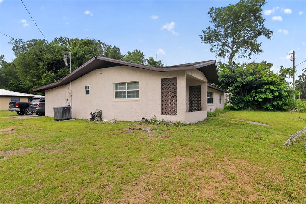 A single-story house with a stucco exterior, a low-pitched roof, and a lattice-screened porch — 1705 EDEN DRIVE, INVERNESS, FL