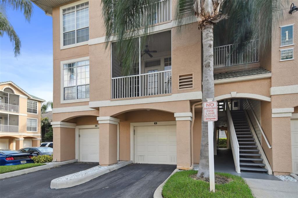 Exterior view of a multi-story apartment building with two garages and an outdoor staircase — 1201 BAY CLUB CIRCLE, TAMPA, FL