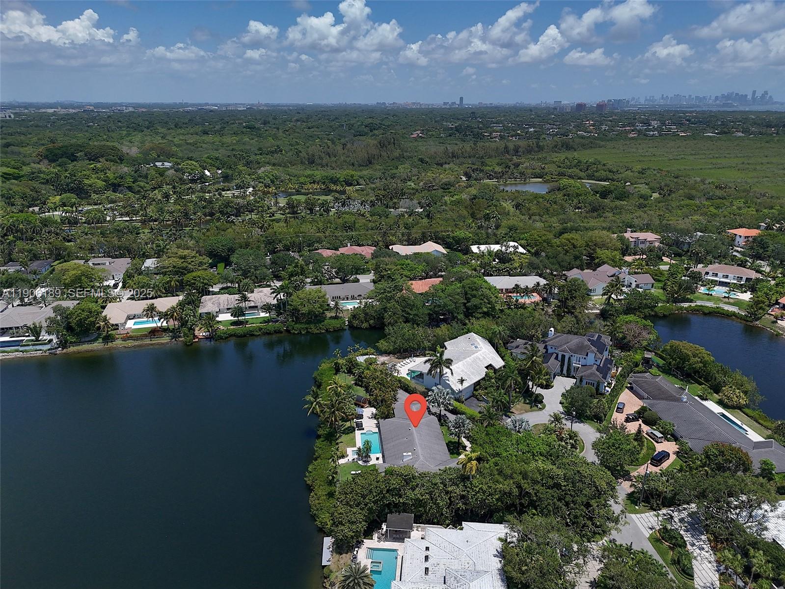 An aerial view shows a waterfront house with a pool and a red location pin — 415 Rovino Ave, Coral Gables FL 33156, CORAL GABLES, FL