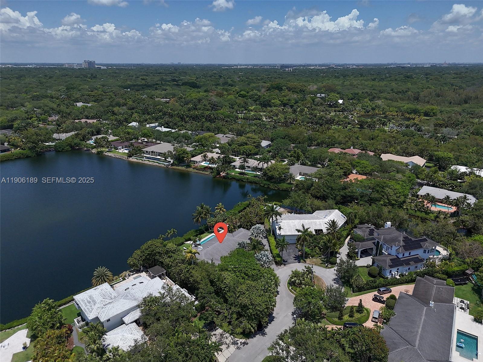 An aerial view shows a waterfront house with a pool marked by a red pin — 415 Rovino Ave, Coral Gables FL 33156, CORAL GABLES, FL