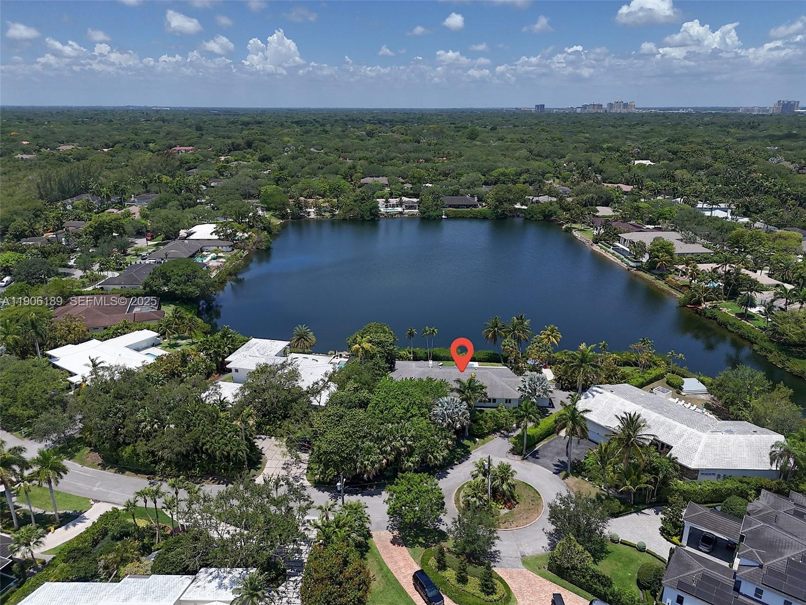 An aerial view shows a house with a red location pin beside a lake — 415 Rovino Ave, Coral Gables FL 33156, CORAL GABLES, FL