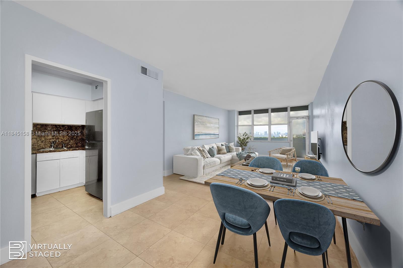 This is a virtually staged living and dining area with tile floors and a kitchen — 7441 Wayne Ave # 15E, Miami Beach FL 33141, MIAMI BEACH, FL
