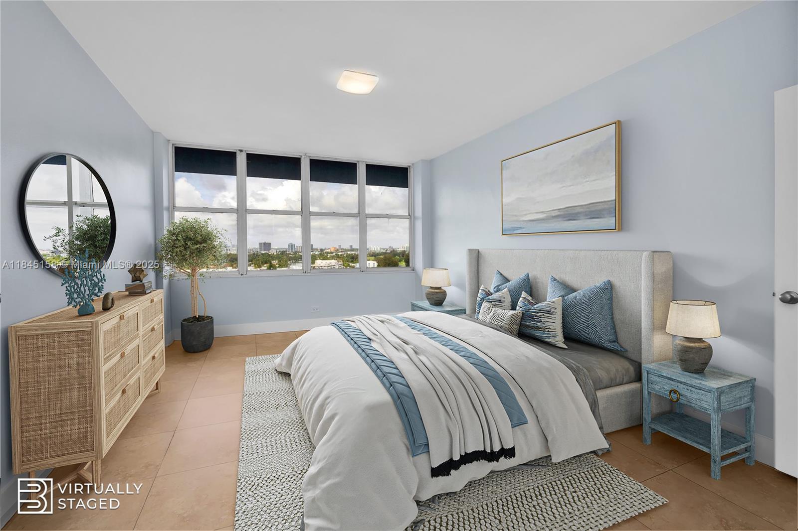 This is a virtually staged bedroom with light blue walls, tile flooring, and city views — 7441 Wayne Ave # 15E, Miami Beach FL 33141, MIAMI BEACH, FL