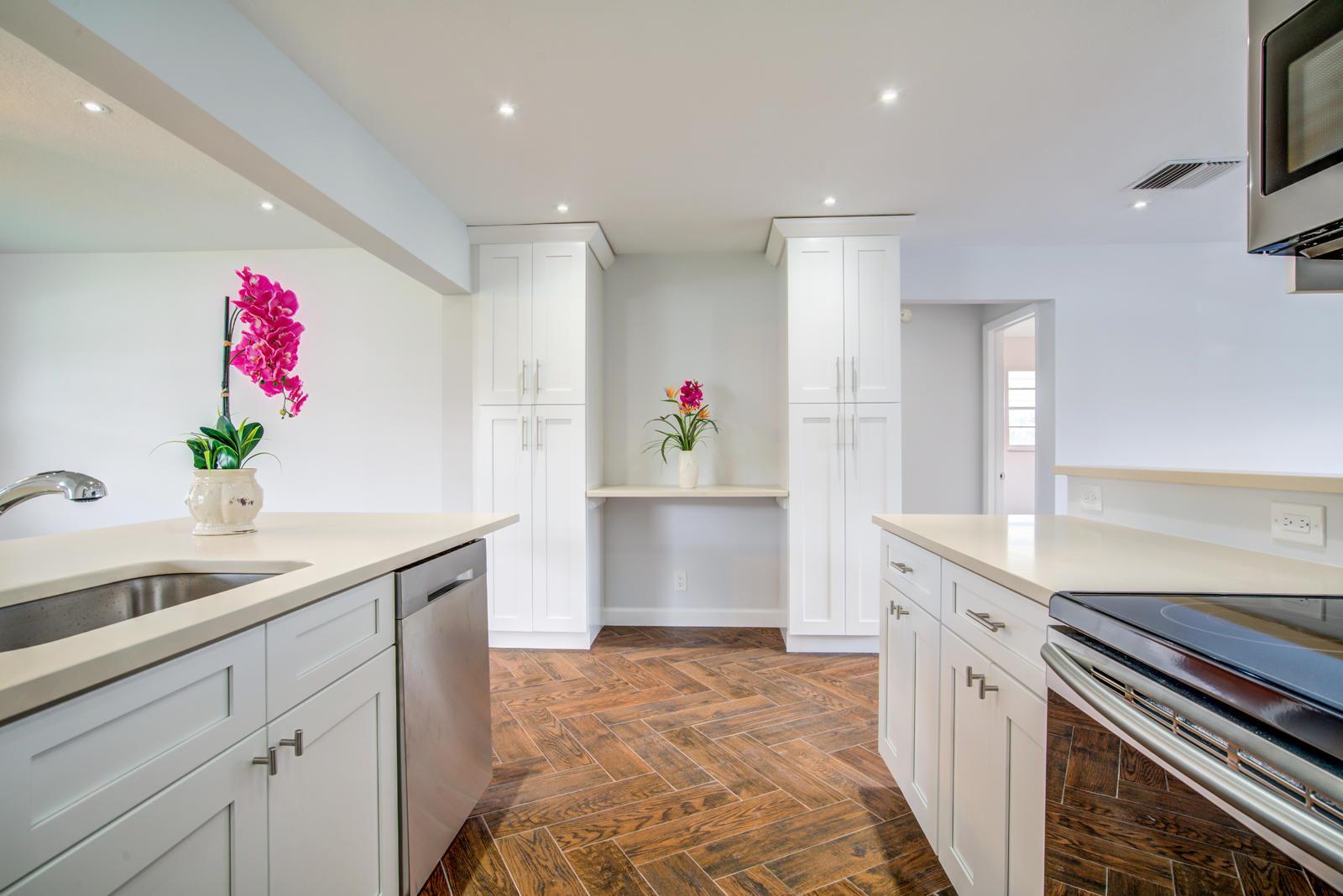 A kitchen with white cabinets, stainless steel appliances, and a herringbone-patterned wood floor — 813 SW 5th Court, Boynton Beach FL 33426, BOYNTON BEACH, FL